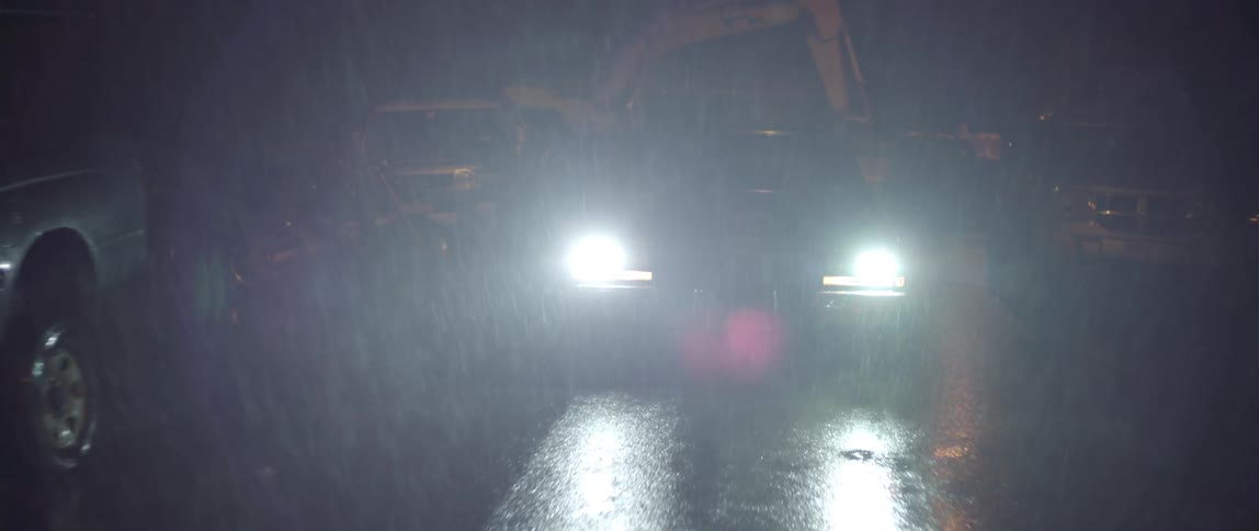 A car driving at night in the rain