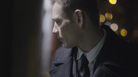 Sunlight shines down on a man in a coat