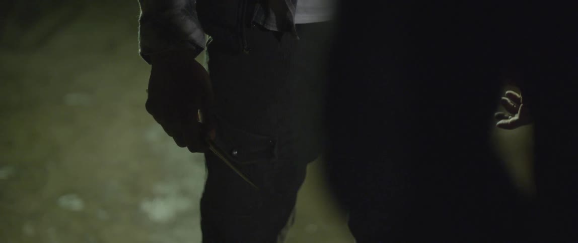 A man is holding a knife in a menacing manner