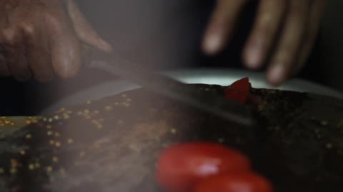 A woman cutting red peppers with precision