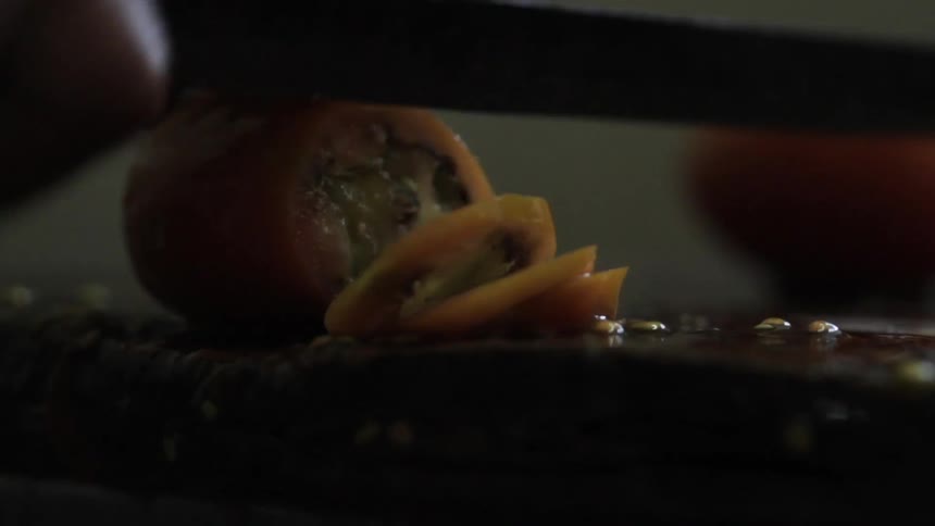 A tomato is diced on a cutting board