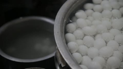 A large pot filled with eggs in water for boiling