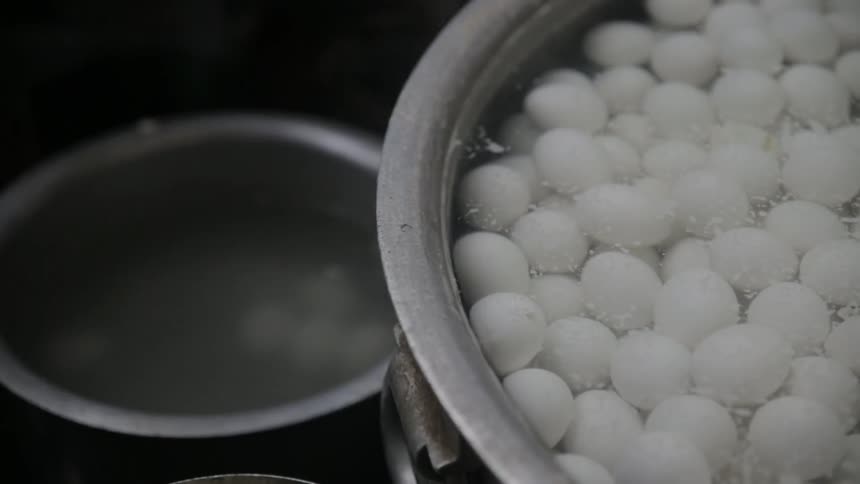 A large pot filled with eggs in water for boiling