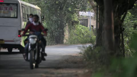 Vehicles pass each other on a shaded road
