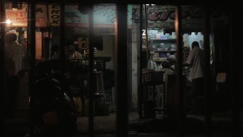 Several people in a busy shop that is somewhat dimly lit