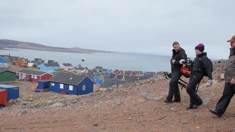 Four men walking down hill with their camera equipment