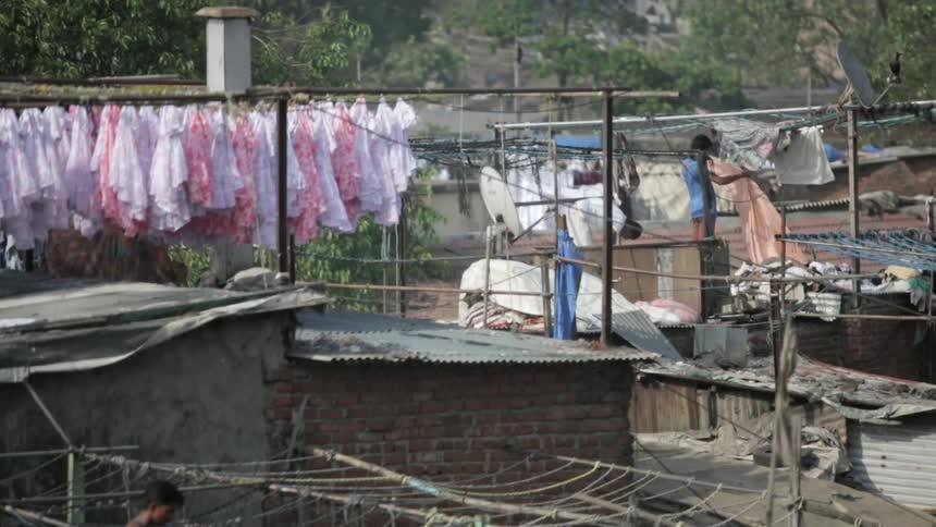 Garments blow in the breeze as people hang other garments nearby