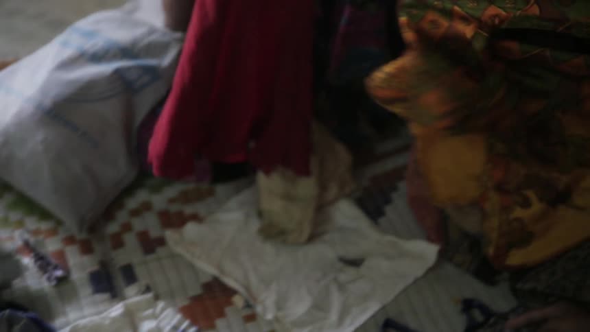 Women tending to clothing with one snatching it from another
