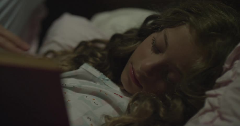 A father gets up as his daughter sleeps
