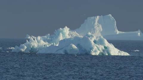 Icebergs in the sea as waves roll around them