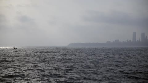 A boat travels across rough waters on a cloudy day