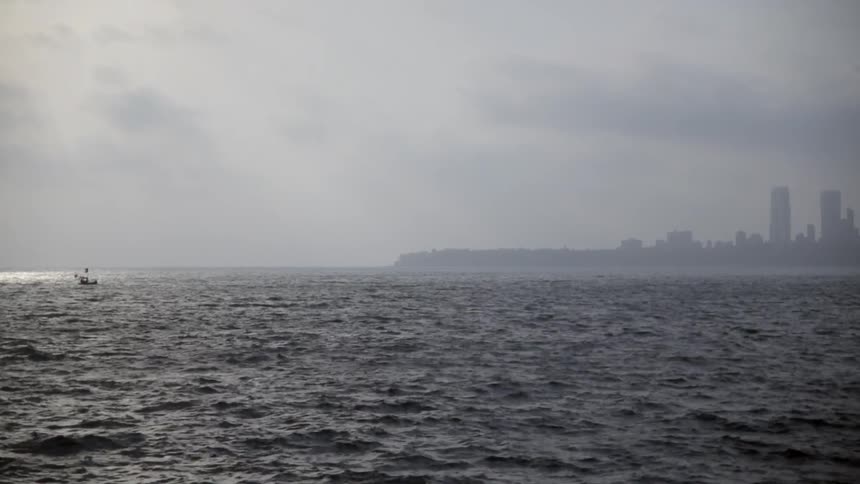 A boat travels across rough waters on a cloudy day