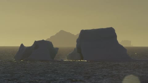 Two large rocks protruding from water on a hazy day