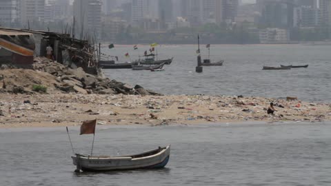 Small boats float near a shack on the shore