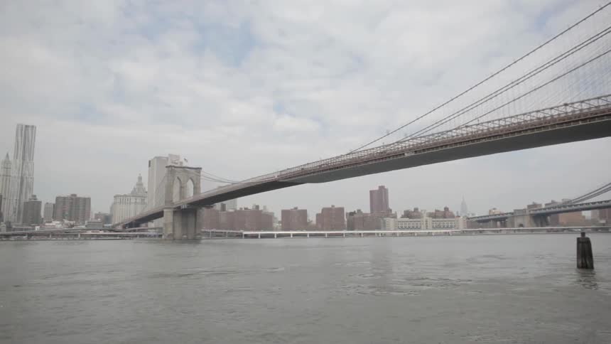A bridge spans a body of water into a city