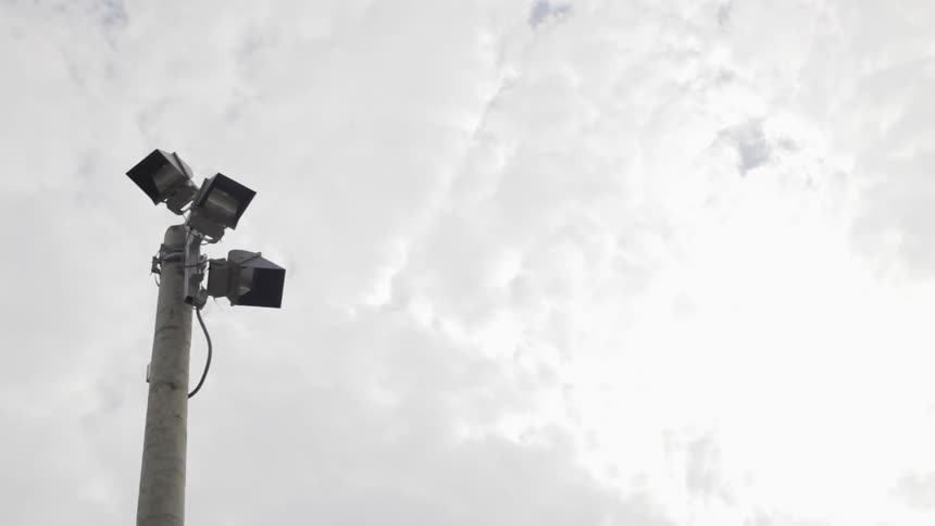 A light pole under a cloudy sky