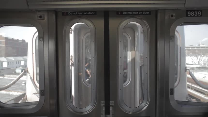 The back door of a train car is shown as the train travels