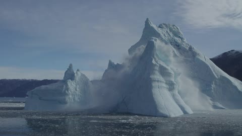 Large piece of ice on the water collapsing in the middle