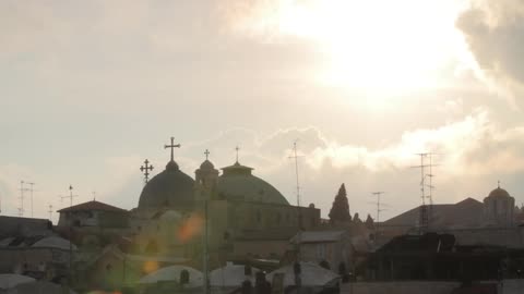 The sun coming out from behind a cloud over a church