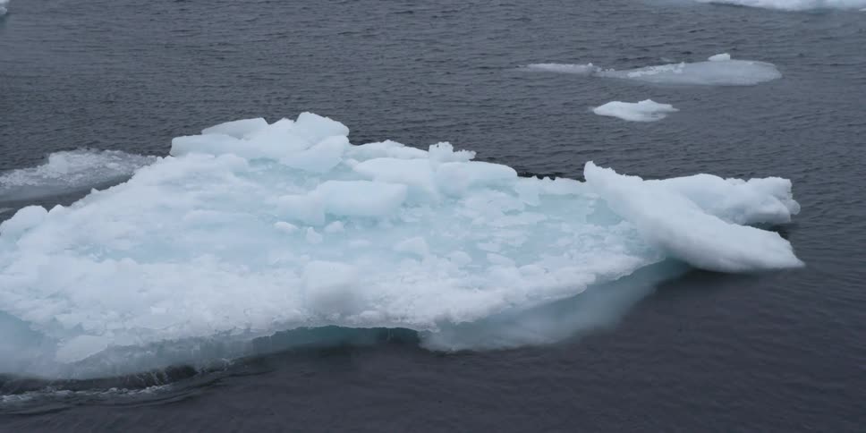 A block of ice floats through a cold ocean