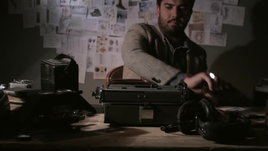 A person sitting down to use a typewriter