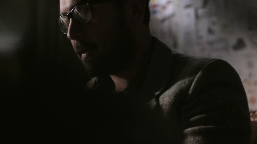 A man in glasses works in his office