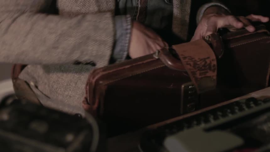 Person looking through a leather bag in a room