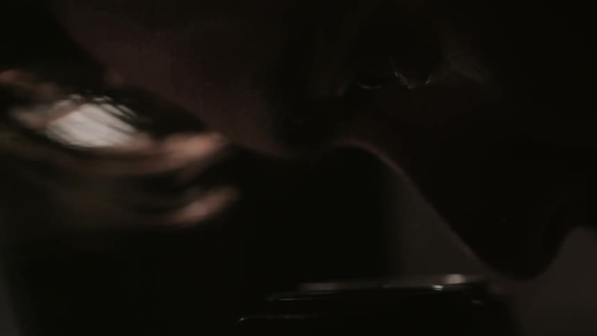 A man peers into a lens of what looks like a camera
