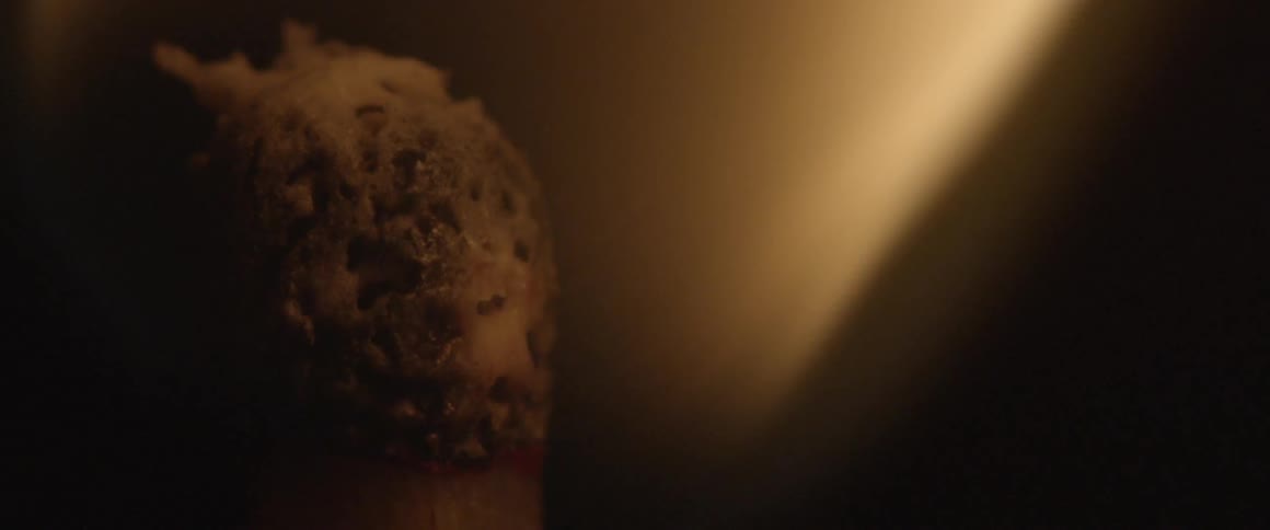 Tip of a match ignites, burns and extinguishes leaving smoke
