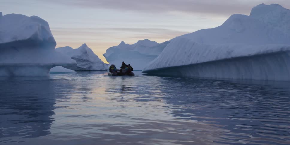A raft floats towards icebergs