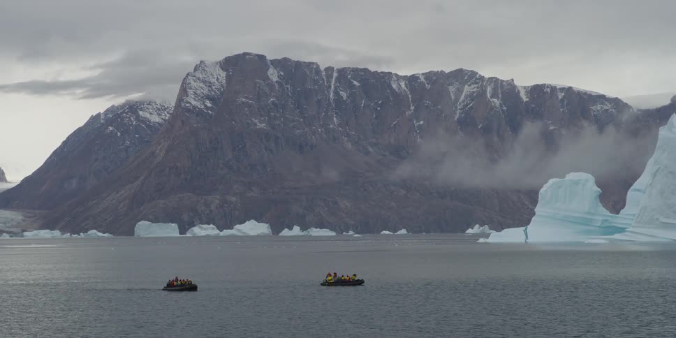 Rafts float in front of glaciers and mountains