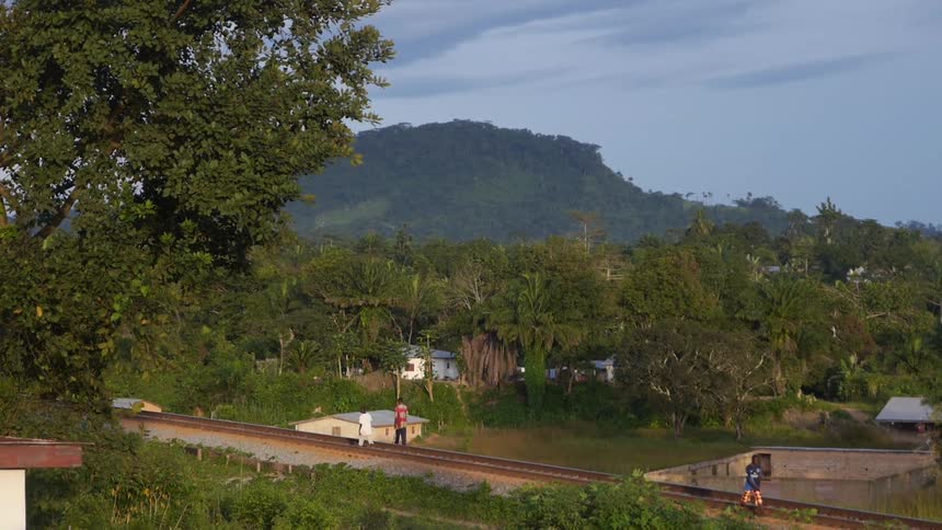 People walk along a train track
