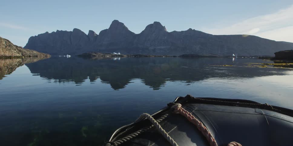 Boat on calm waters with mountains in the distance