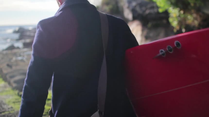 A person walking with a surfboard