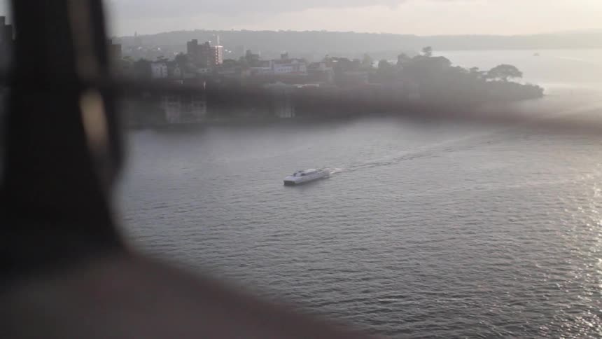 Boat traveling down the water near a town on a cloudy day