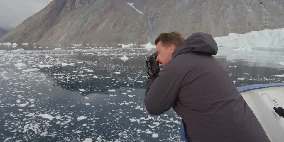 A man videos an ice-filled body of water