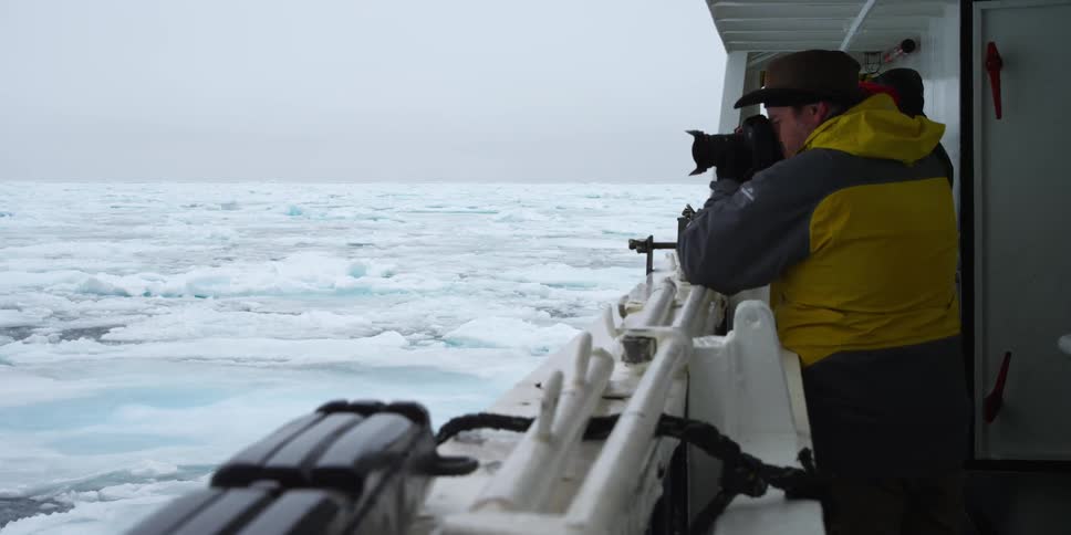A man takes pictures from a large boat