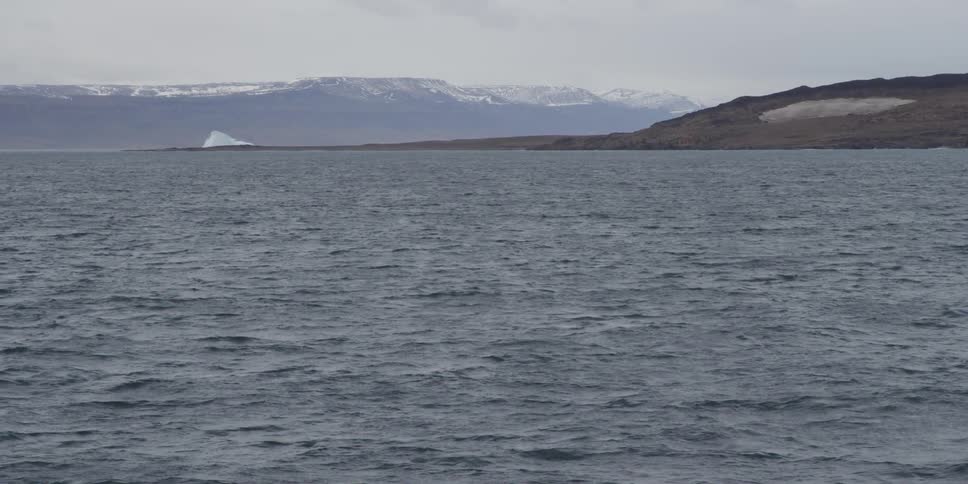 Snow covered mountains are seen across a body of water