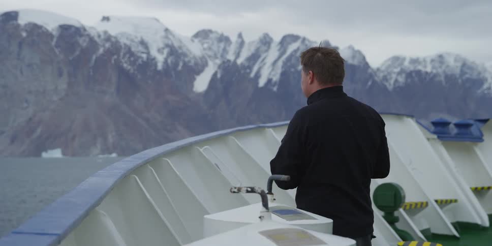 A man taking pictures of a snowy mountain