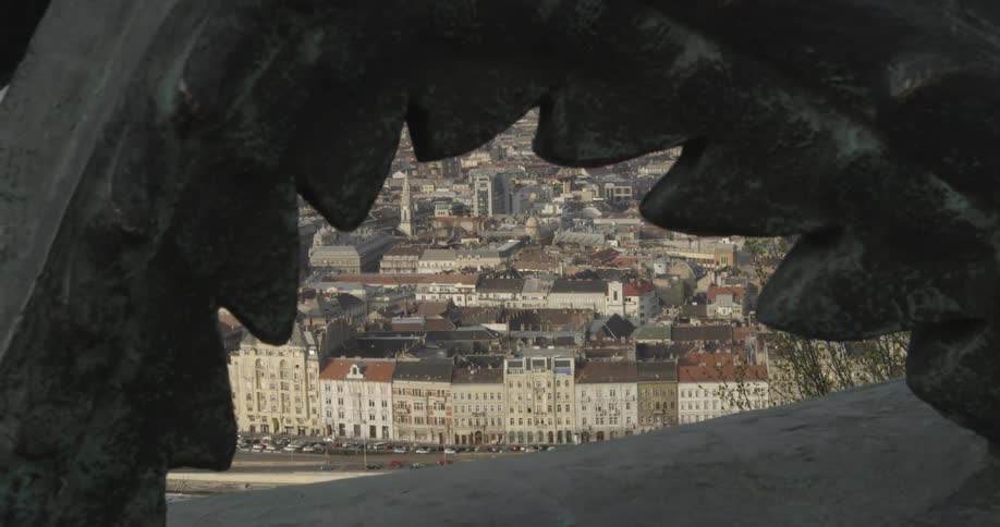 A city by the sea through an opening in a statue