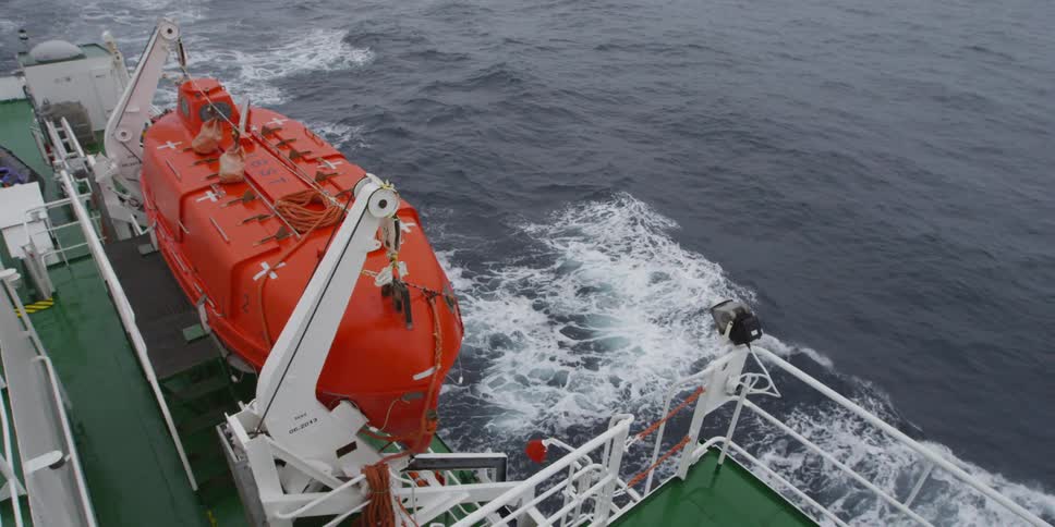 A transport ship towing a smaller vessel