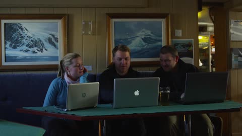 People sit at a table with their laptops