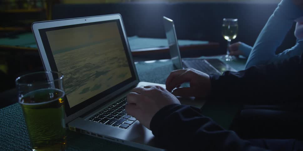 A man and woman look at pictures of polar bears and ice on a laptop