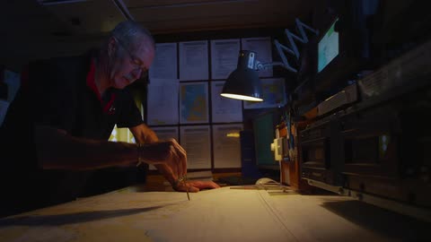 A man uses a protractor on a map