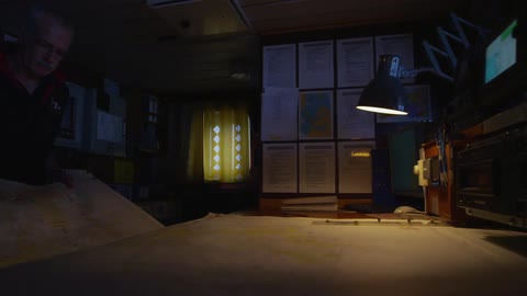 Man studying a map on a table in a dark room