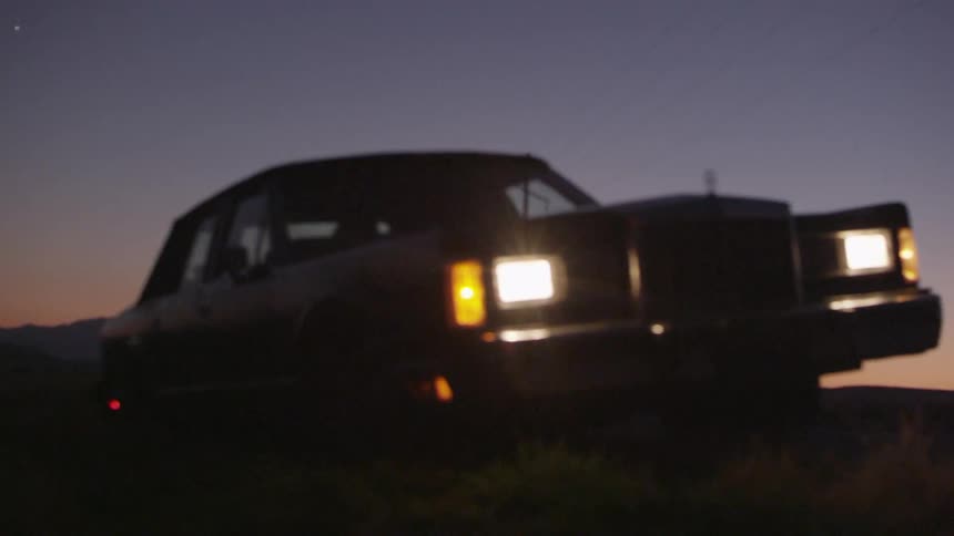 A car parked with its headlights on