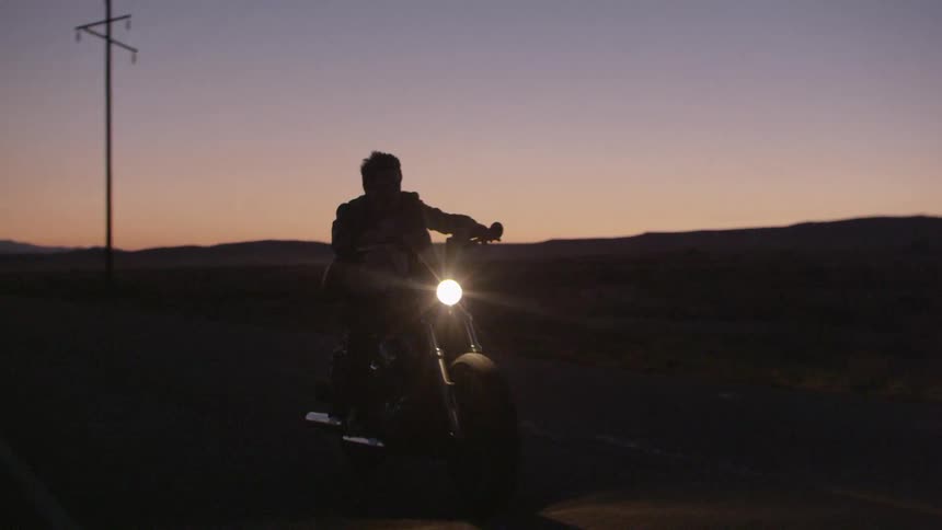 A man drives a motorcycle at night