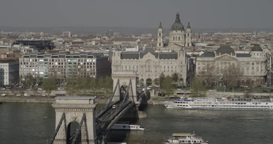 Boats ferry along a river with a city in the background