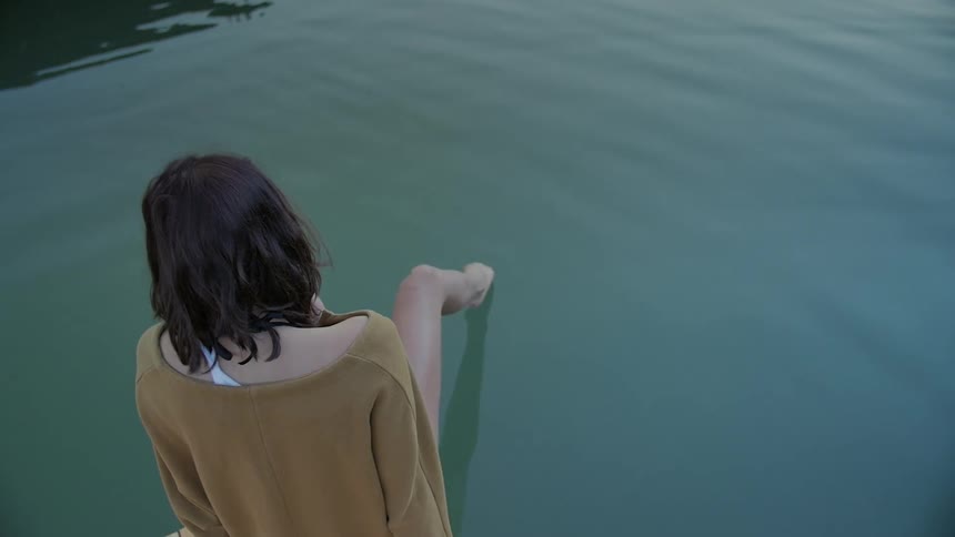 A woman touches her foot to a water surface