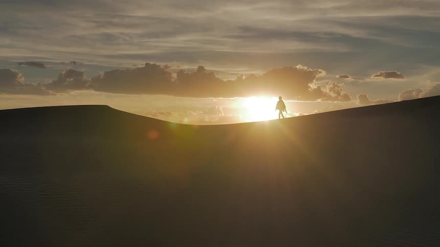A person walking on a hill in the sun